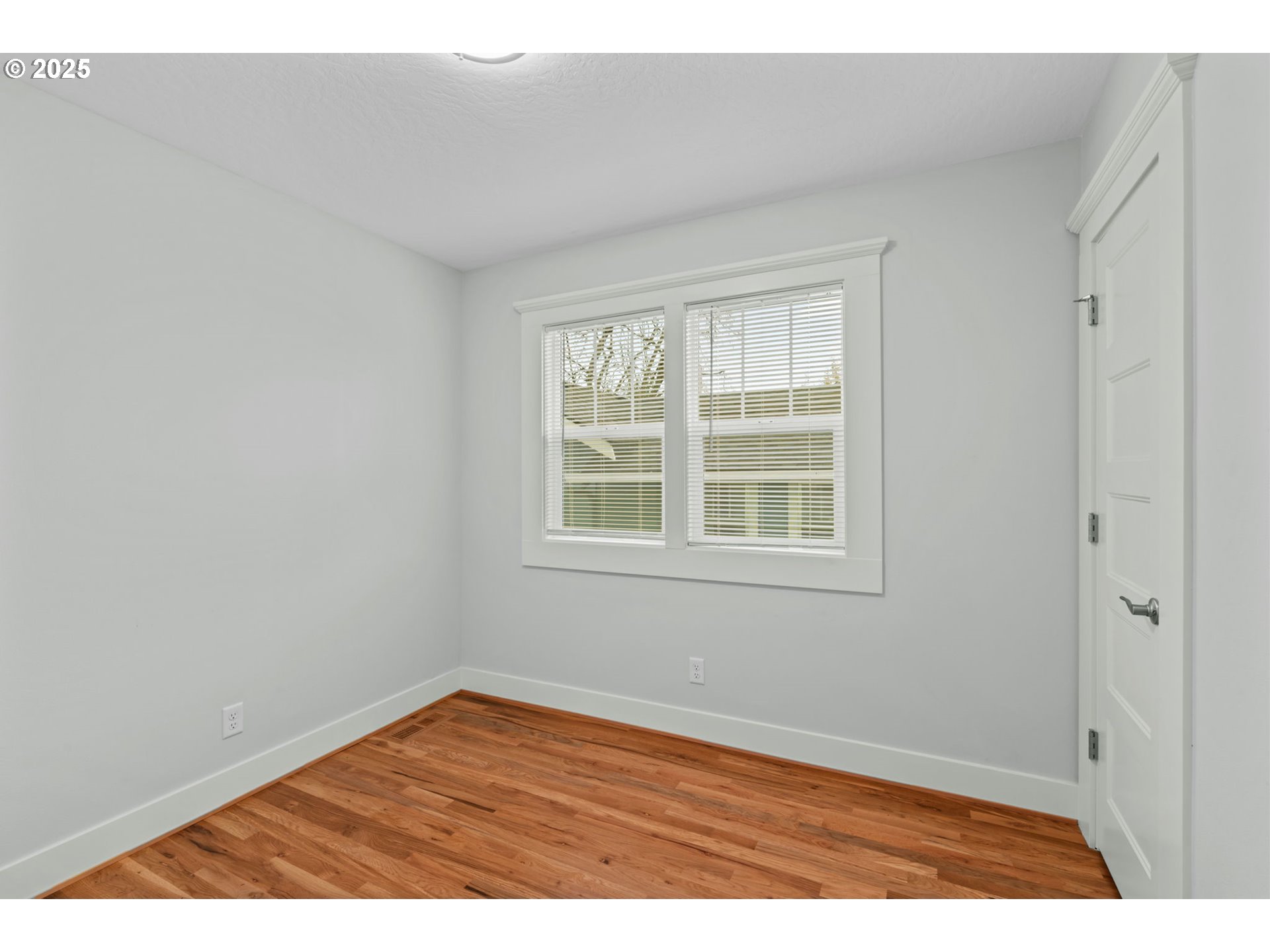 1010 Monroe Street Eugene, OR 97402 - Photo 16 of 40 an empty room with wooden floor and windows