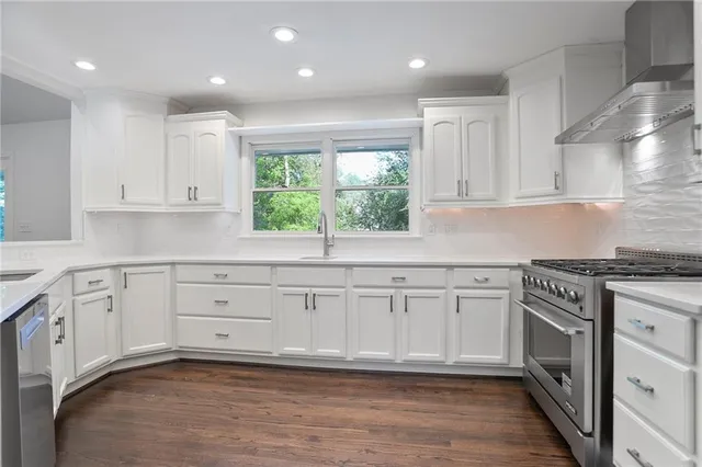 a kitchen with granite countertop white cabinets and white appliances