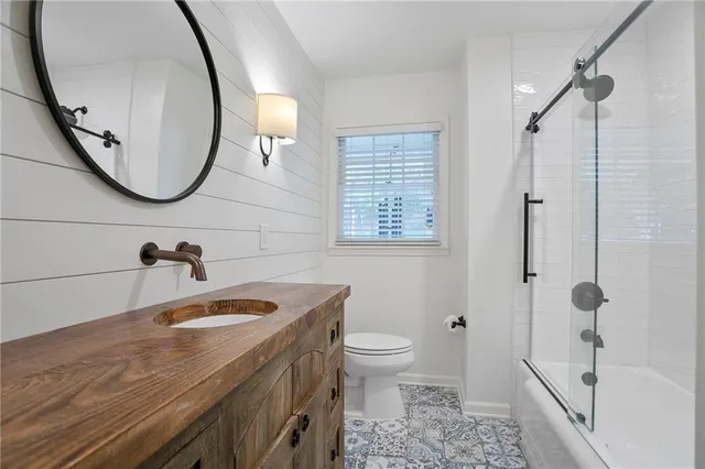 a bathroom with a sink a toilet and a mirror