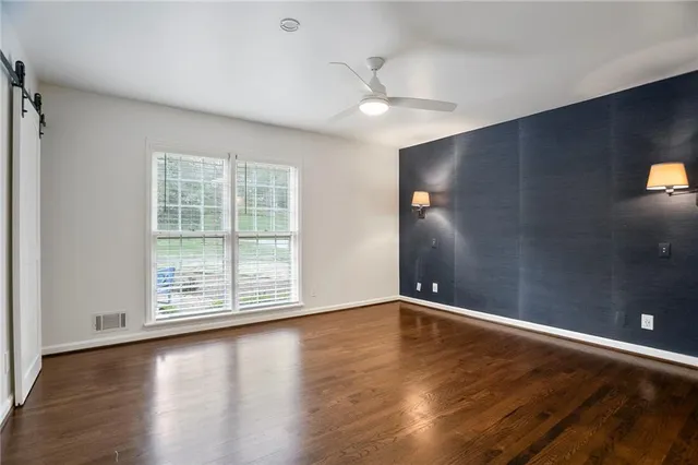 an empty room with wooden floor and windows