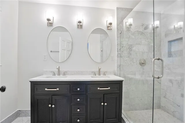 a bathroom with a double vanity sink mirror and shower