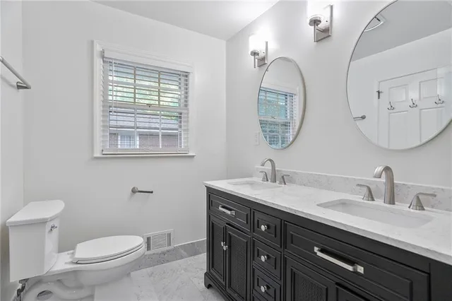 a bathroom with a toilet a sink and a mirror