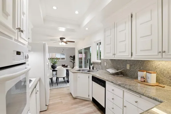a kitchen with granite countertop a sink stainless steel appliances and cabinets