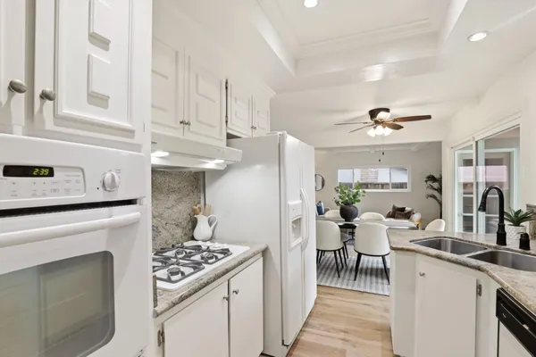 a kitchen with stainless steel appliances granite countertop a stove refrigerator and cabinets
