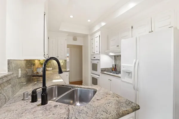 a kitchen with stainless steel appliances granite countertop a sink stove and refrigerator