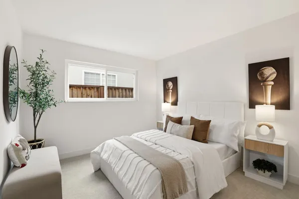 a bedroom with a bed and a potted plant
