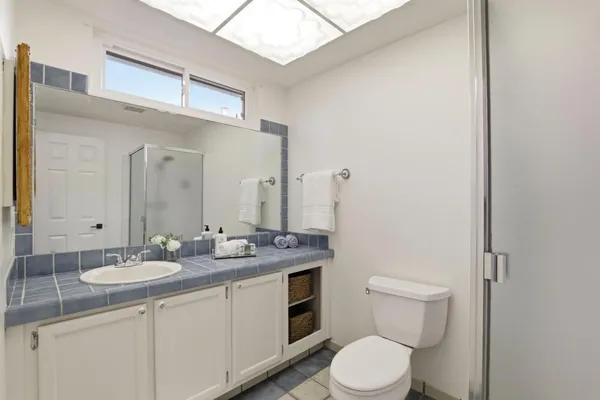 a bathroom with a granite countertop toilet sink and mirror