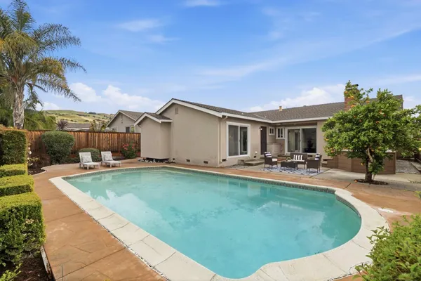a view of a house with swimming pool and sitting area