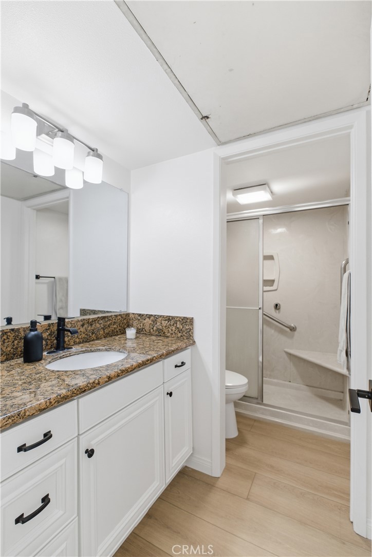 20921 Serrano Creek Road, Unit 55 Lake Forest, CA 92630 - Photo 14 of 26 a bathroom with a granite countertop sink toilet and shower
