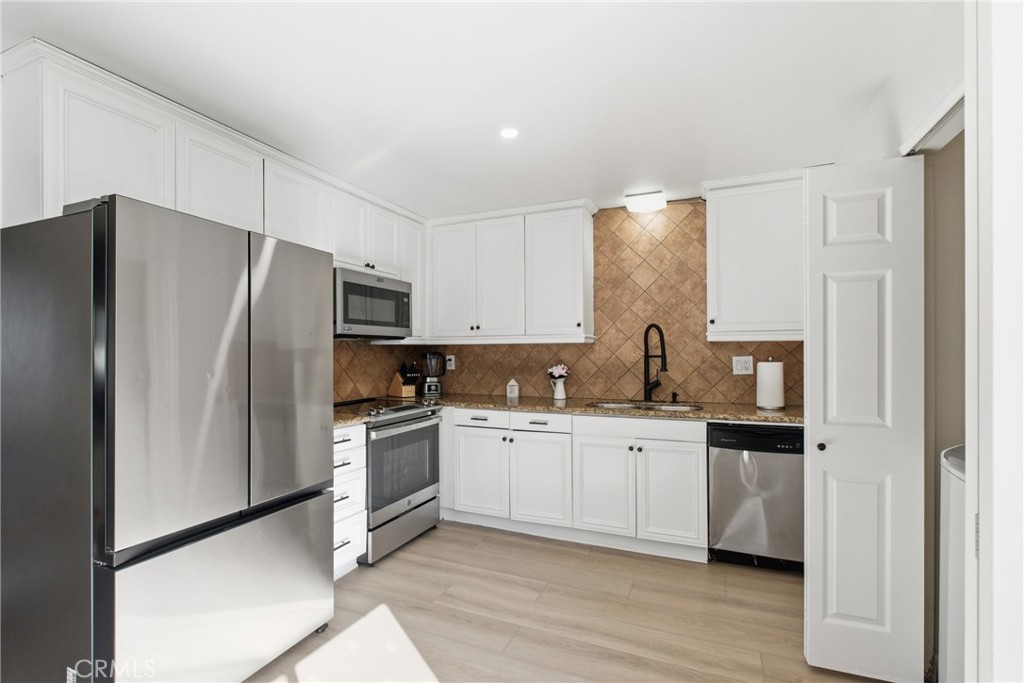 20921 Serrano Creek Road, Unit 55 Lake Forest, CA 92630 - Photo 8 of 26 a kitchen with stainless steel appliances a refrigerator sink and cabinets