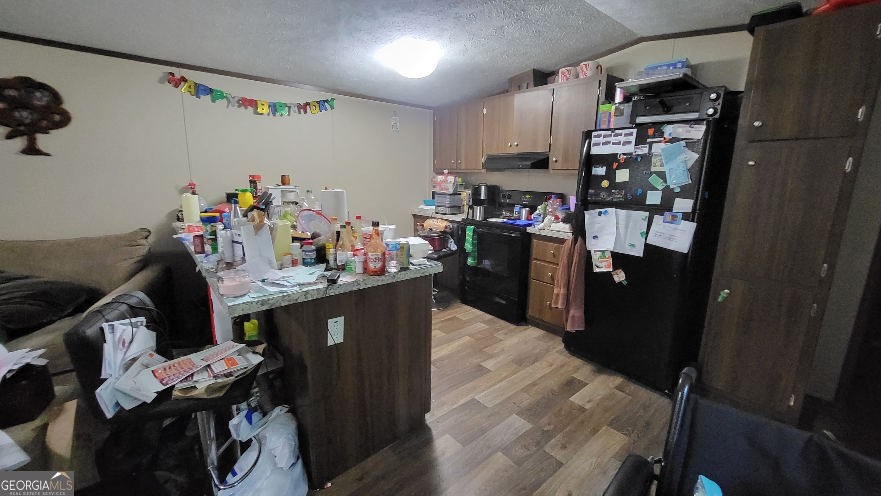 835 Center Of The World Road Canon, GA 30520 - Photo 3 of 9 a kitchen with kitchen island granite countertop lots of clutter and stainless steel appliances