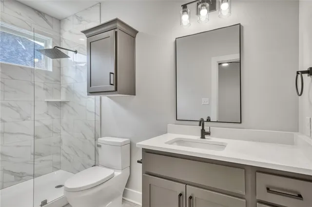 a bathroom with a sink a toilet and shower