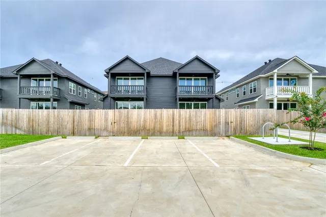 a front view of a house with a yard and wooden fence