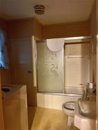 a bathroom with a sink a toilet and shower