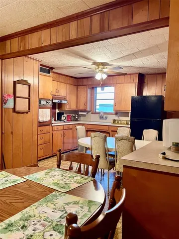 a kitchen with stainless steel appliances granite countertop a sink dishwasher and a refrigerator with wooden cabinets