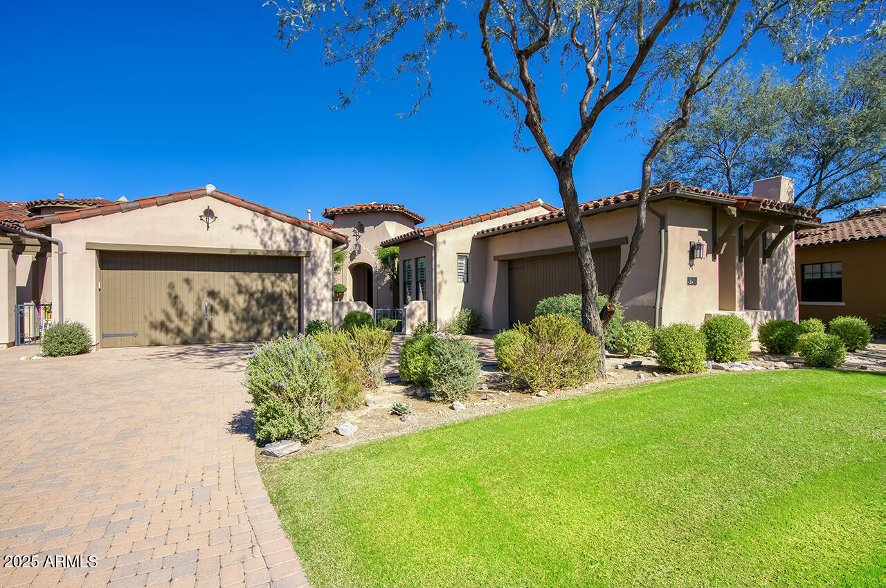 9190 East Hoverland Road Scottsdale, AZ 85255 - Photo 2 of 35 a front view of a house with a yard and garage