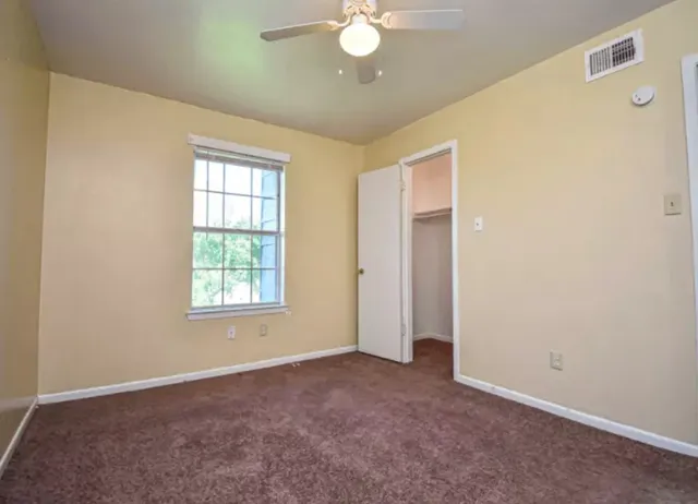 an empty room with windows and closet