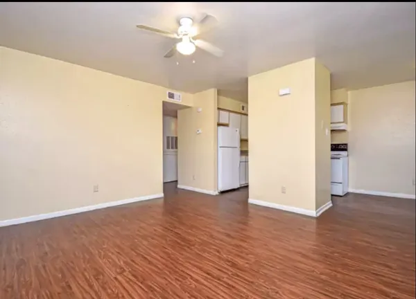 a view of an empty room with wooden floor