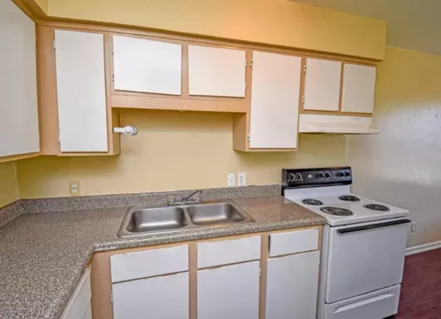 a kitchen with a sink cabinets and a window
