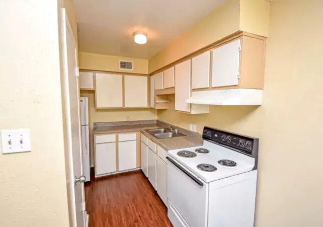 a kitchen with a stove a sink and a refrigerator
