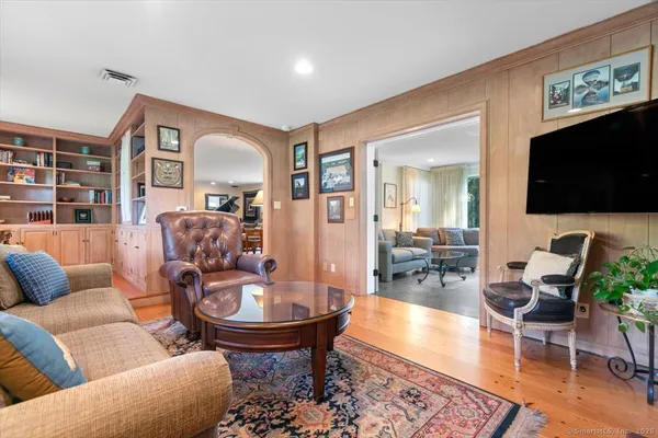 a living room with furniture a flat screen tv and kitchen view
