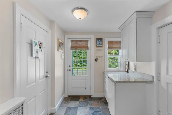 a bathroom with a granite countertop sink and a window