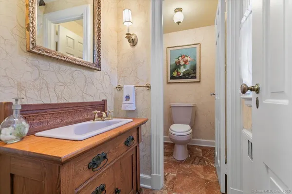 a bathroom with a sink a toilet and mirror