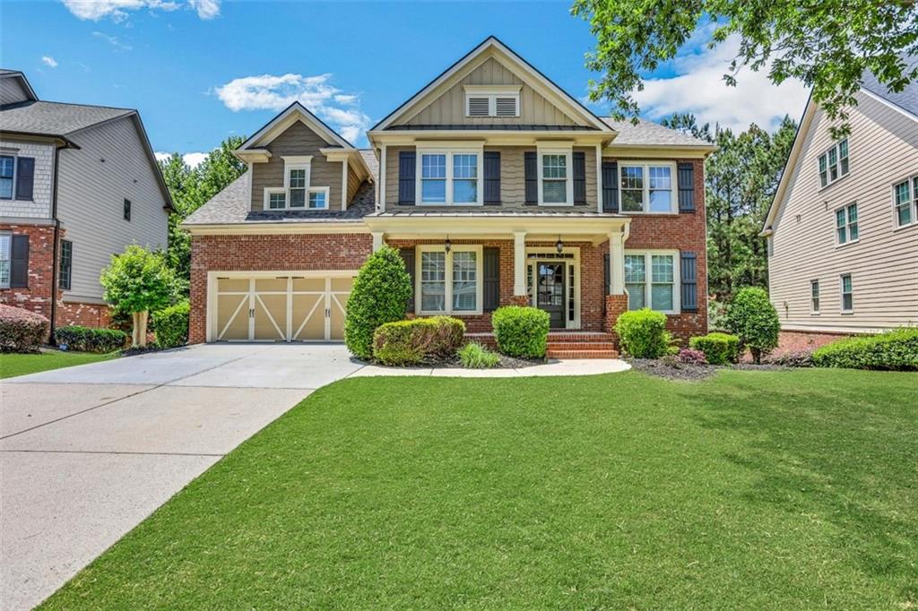 a front view of a house with a yard and trees