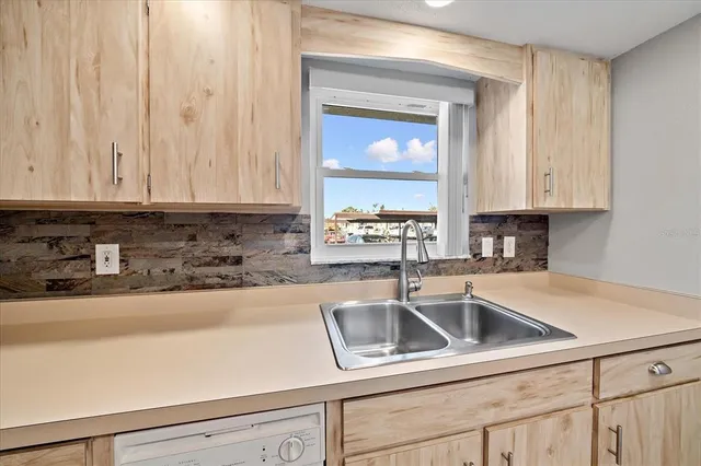 a kitchen with stainless steel appliances granite countertop white cabinets a sink and dishwasher