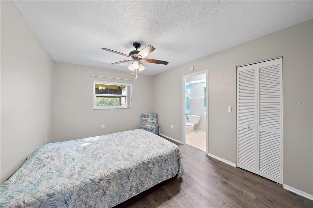 1946 Settlement Road, Unit 24 Venice, FL 34285 - Photo 3 of 36 a bedroom with a large bed and a chandelier