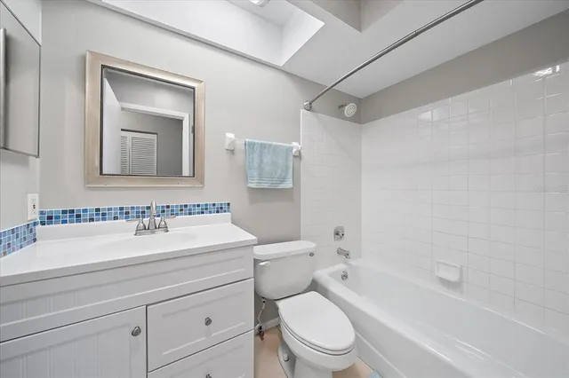 a bathroom with a toilet a sink a mirror a bathtub and vanity