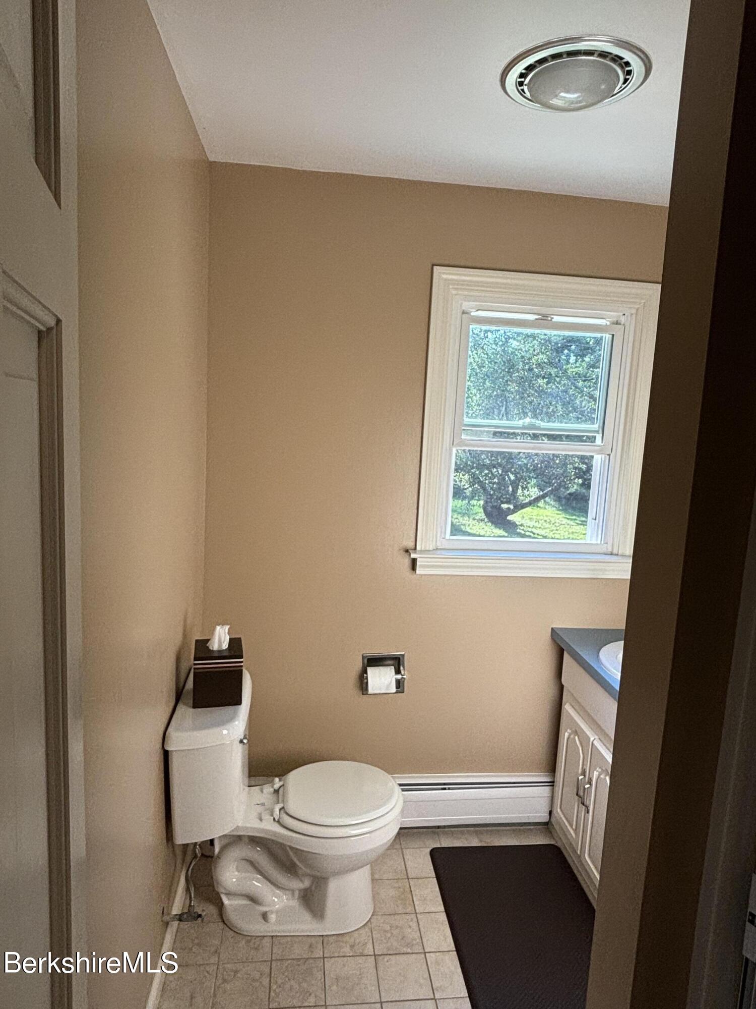 1435 River Road Clarksburg, MA 01247 - Photo 22 of 55 a white toilet sitting next to a bathroom sink and a window