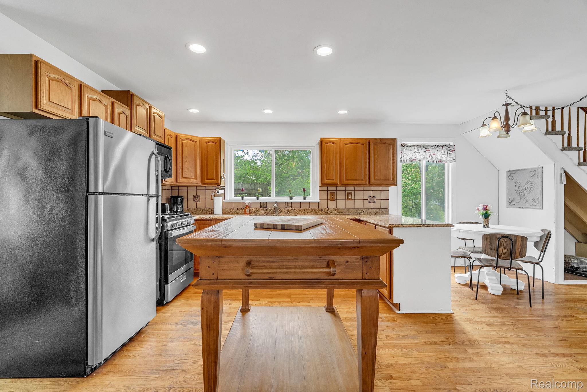 7489 Aspen Road Lexington, MI 48450 - Photo 23 of 62 Kitchen featuring wood-finish flooring, recessed lighting, wood cabinetry, stainless steel appliances, and a central wood island