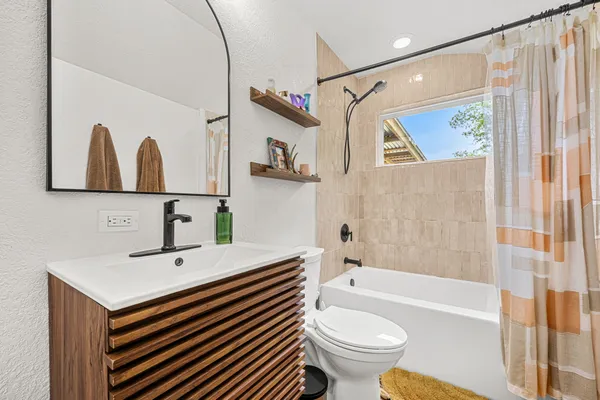 a view of a house with wooden fence and a large tree
