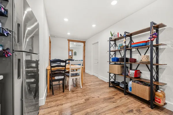 a bedroom with a bed and a dresser with wooden floor