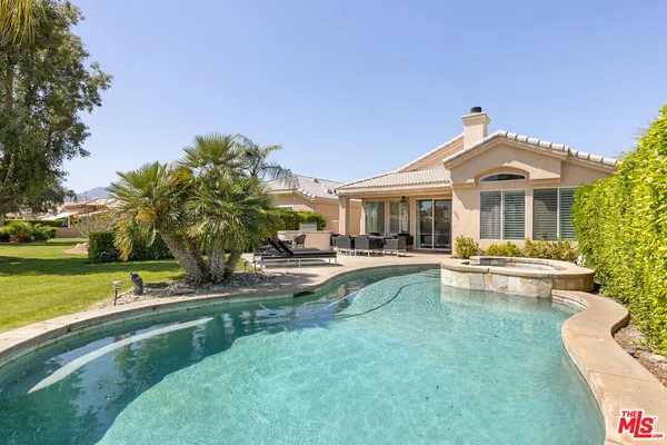 a view of a house with swimming pool and sitting area