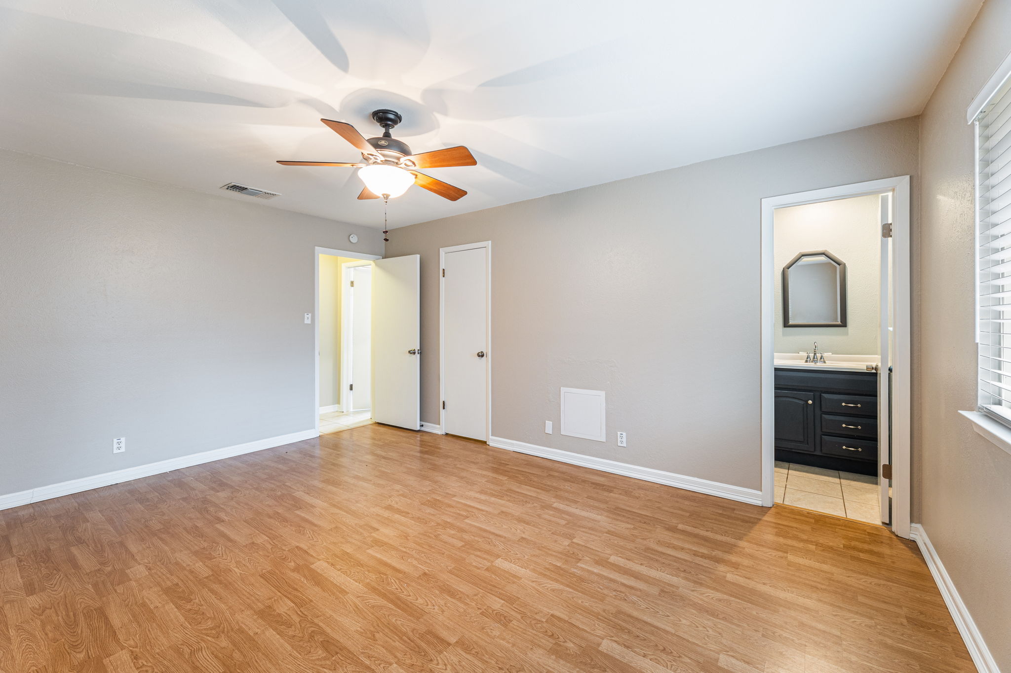 12914 Pegasus Street Austin, TX 78727 - Photo 15 of 30 Unfurnished bedroom with light wood-style flooring, ensuite bathroom, and a ceiling fan
