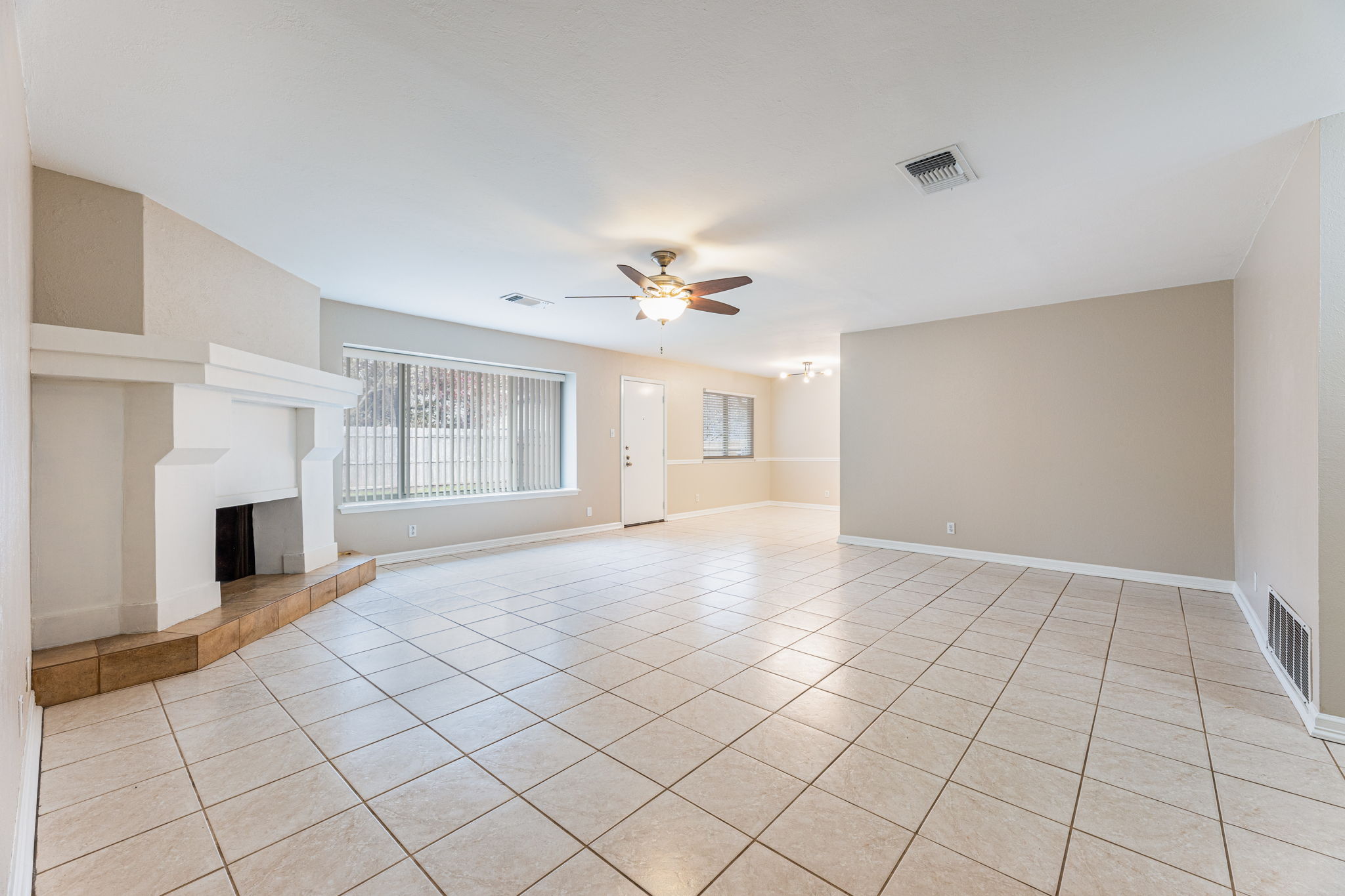 12914 Pegasus Street Austin, TX 78727 - Photo 5 of 30 Unfurnished living room with a tiled fireplace, ceiling fan, and light tile patterned floors