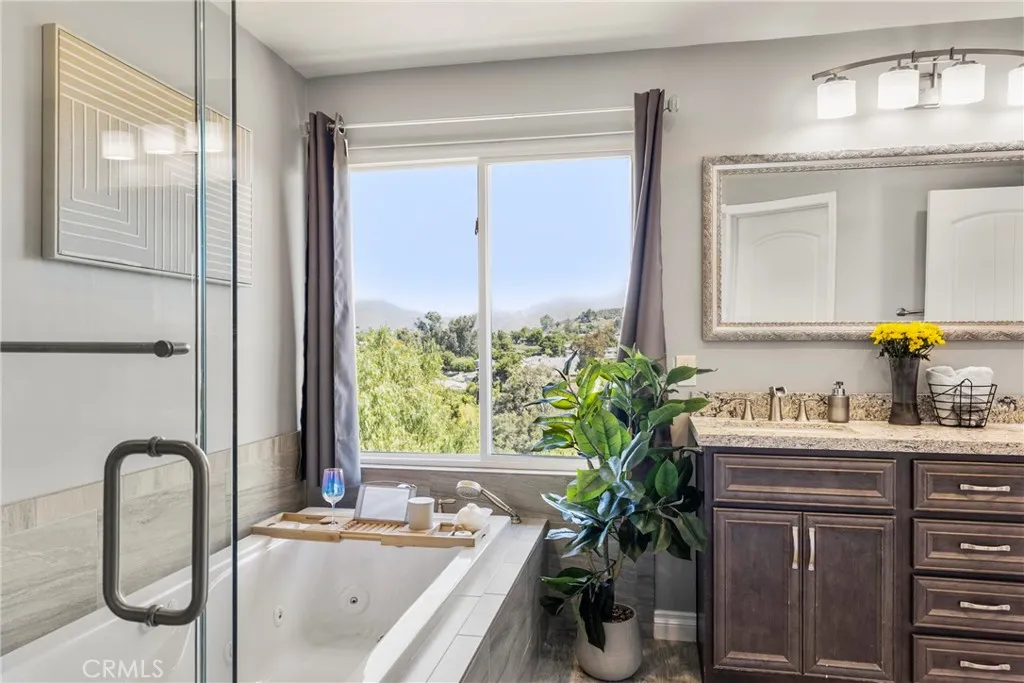 8861 Los Coches Road, Unit 1 Lakeside, CA 92040 - Photo 25 of 45 a bathroom with a granite countertop sink a large mirror and a window