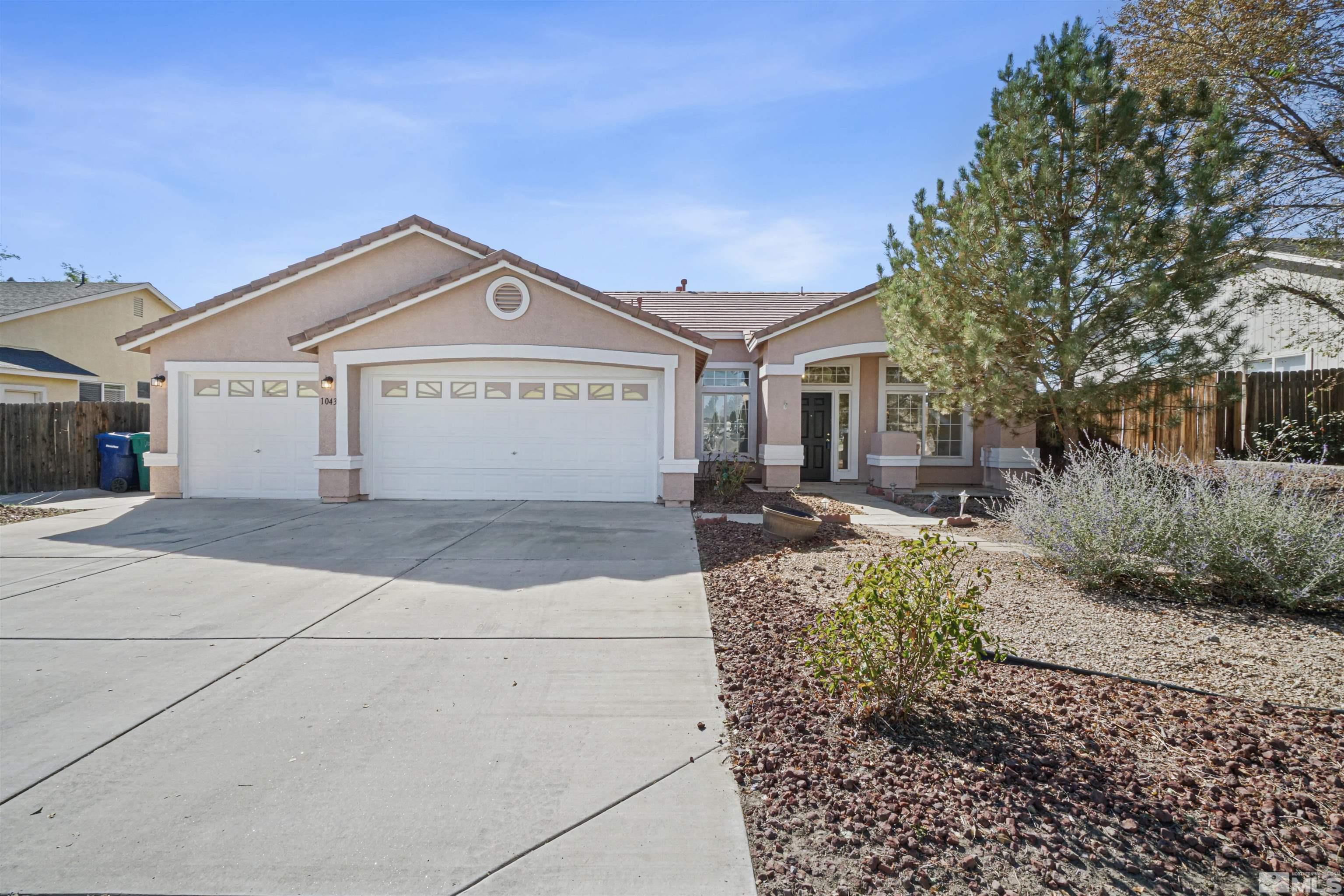 1043 Brierwood Lane Fernley, NV 89408 - Photo 1 of 27 a front view of a house with a yard and garage