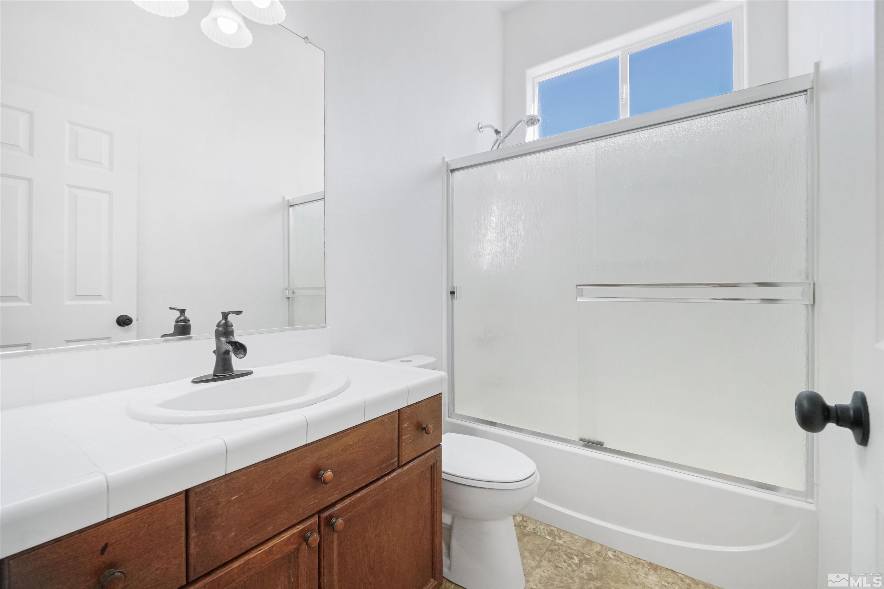 1043 Brierwood Lane Fernley, NV 89408 - Photo 19 of 27 a bathroom with a sink a toilet and shower