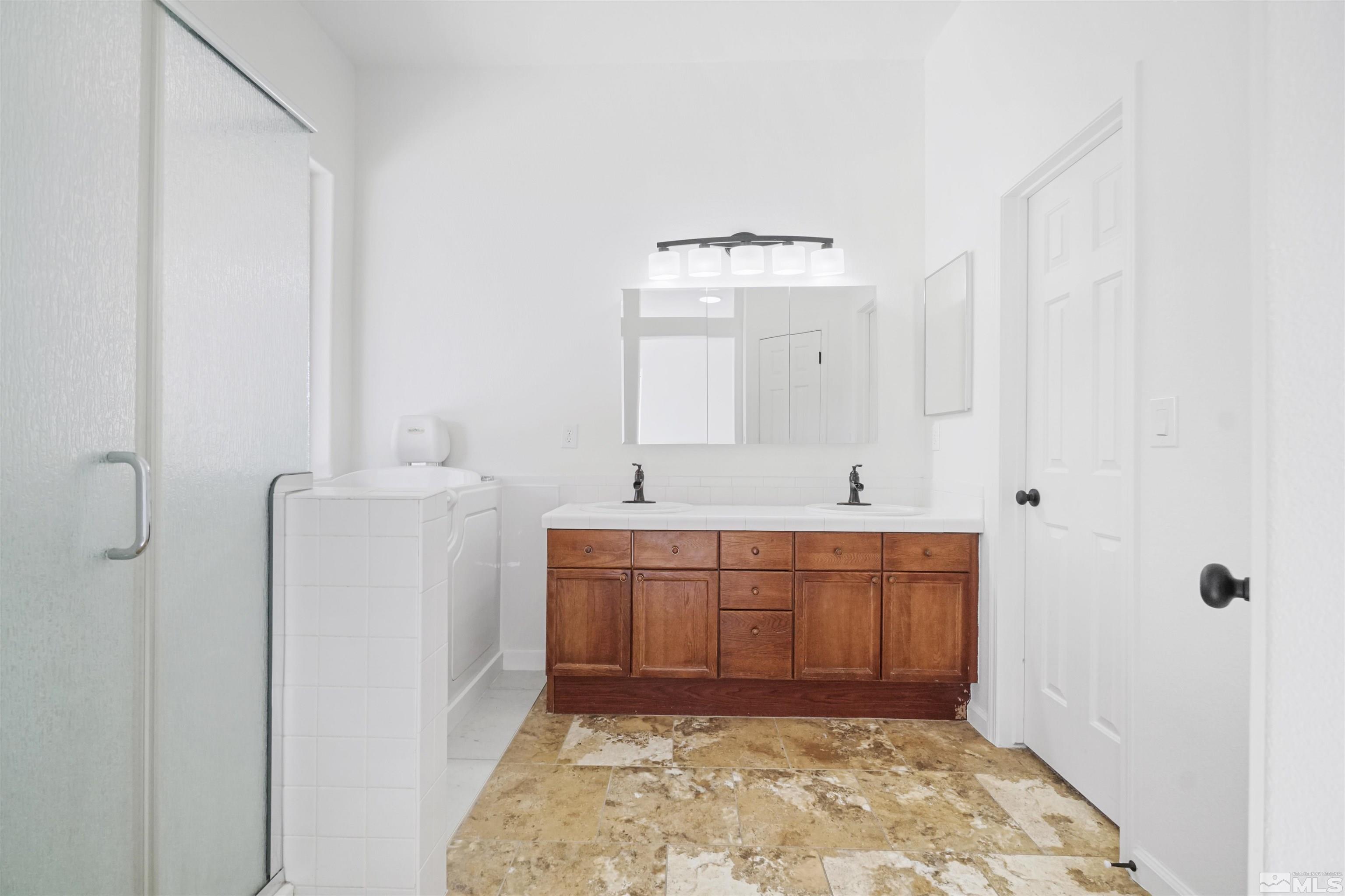 1043 Brierwood Lane Fernley, NV 89408 - Photo 20 of 27 a spacious bathroom with a sink a mirror and a toilet