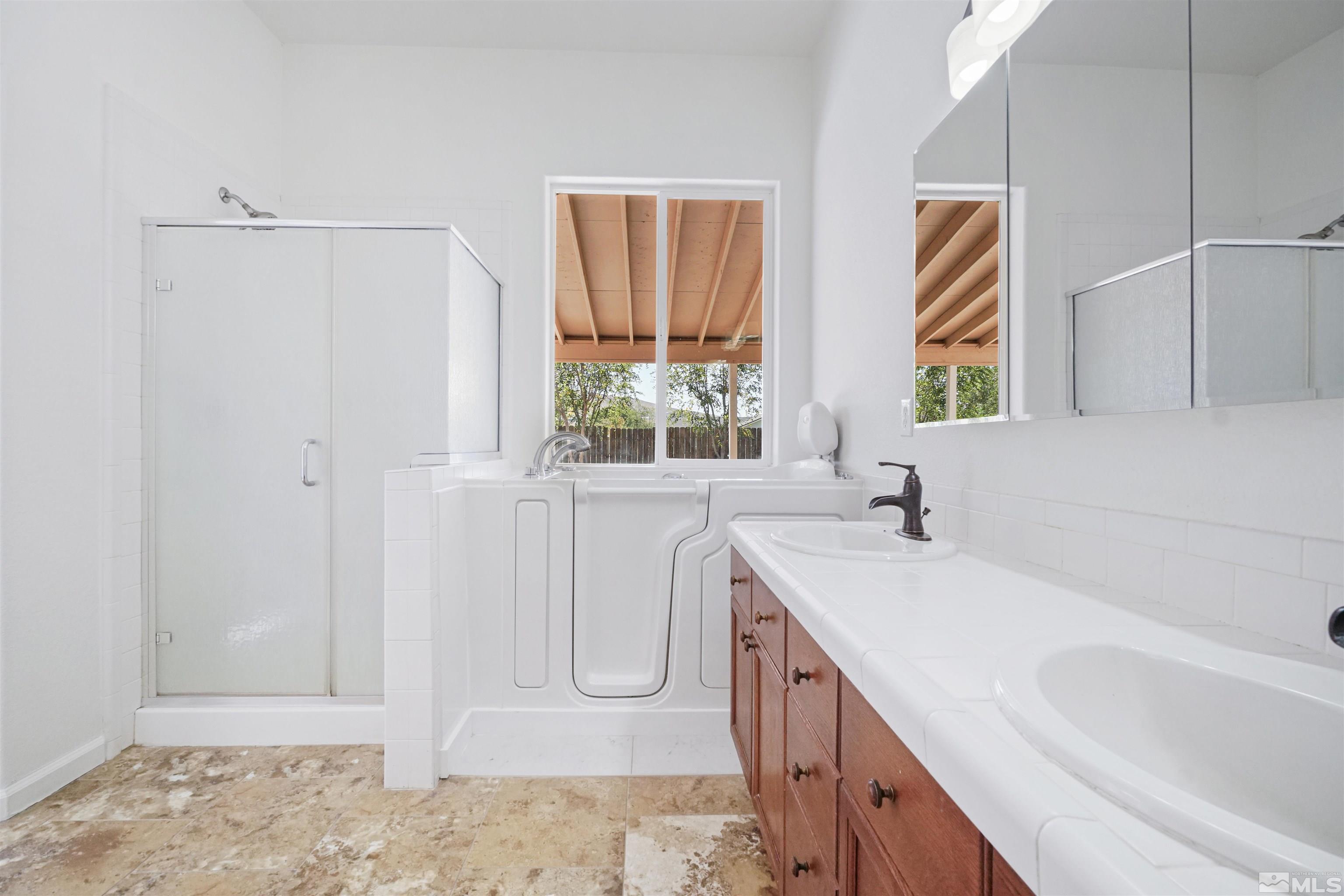 1043 Brierwood Lane Fernley, NV 89408 - Photo 21 of 27 a bathroom with a sink a vanity and a bathtub