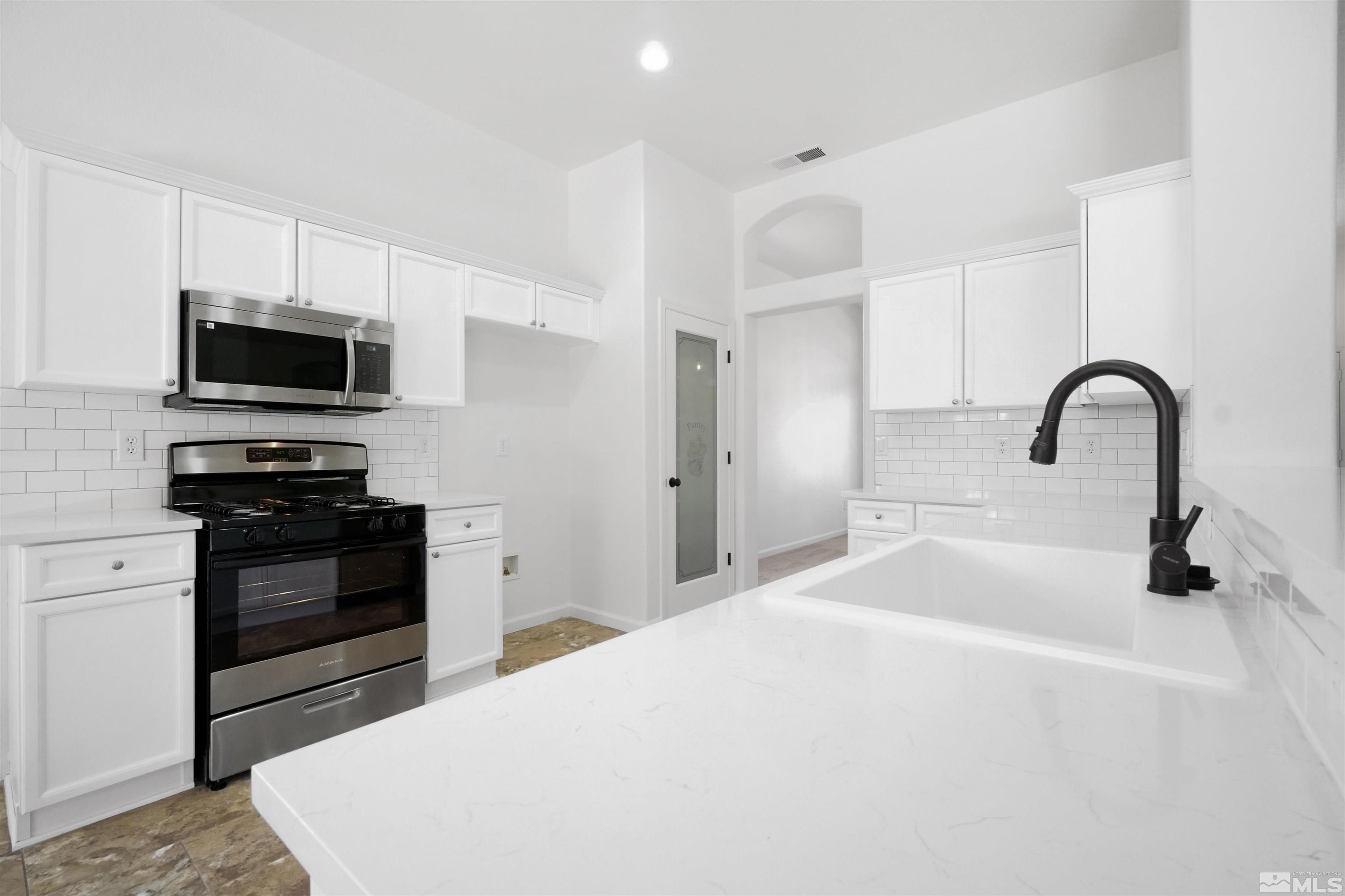 1043 Brierwood Lane Fernley, NV 89408 - Photo 4 of 27 a kitchen with a sink stainless steel appliances and cabinets