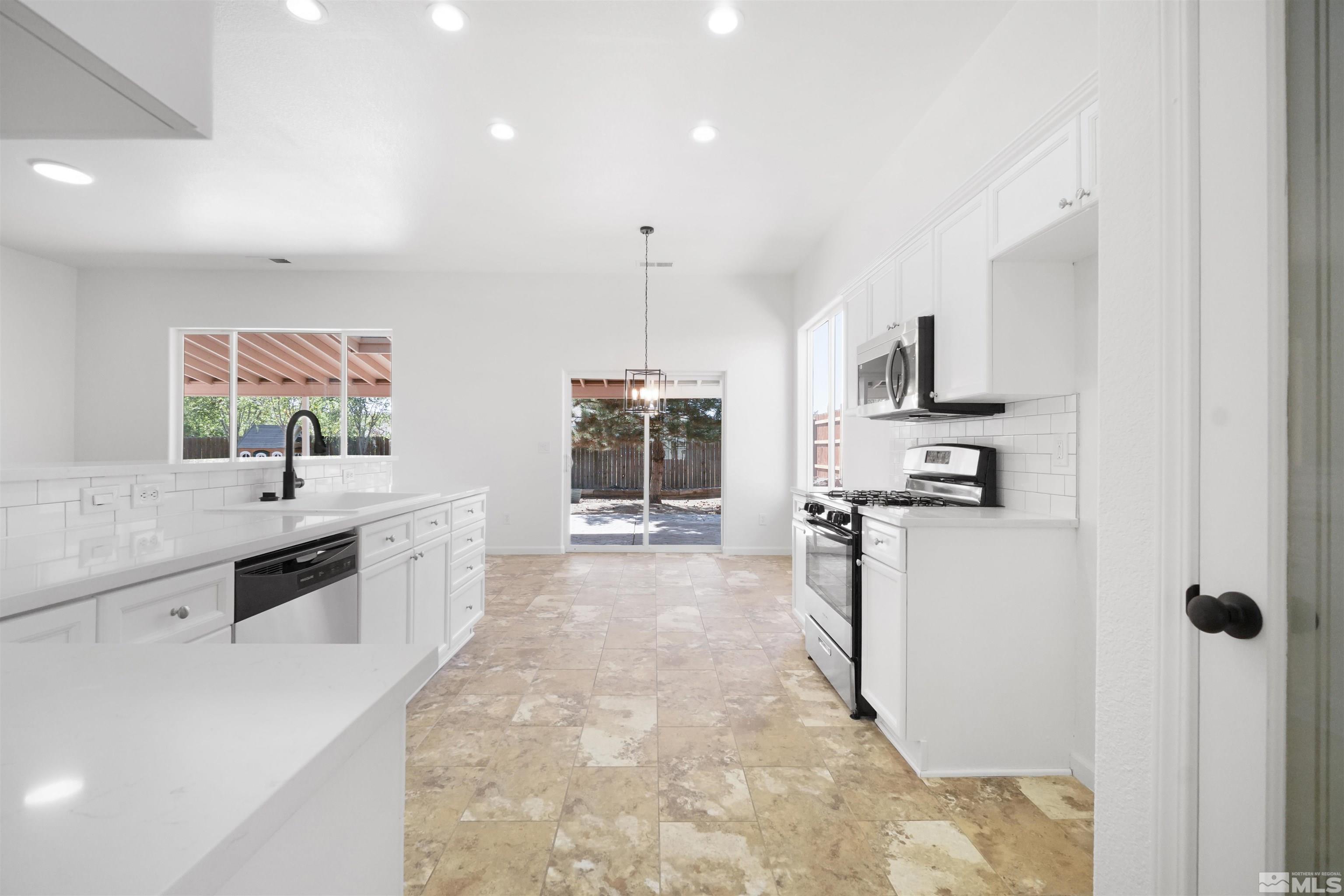1043 Brierwood Lane Fernley, NV 89408 - Photo 7 of 27 a large white kitchen with a stove a sink a refrigerator and a counter top space