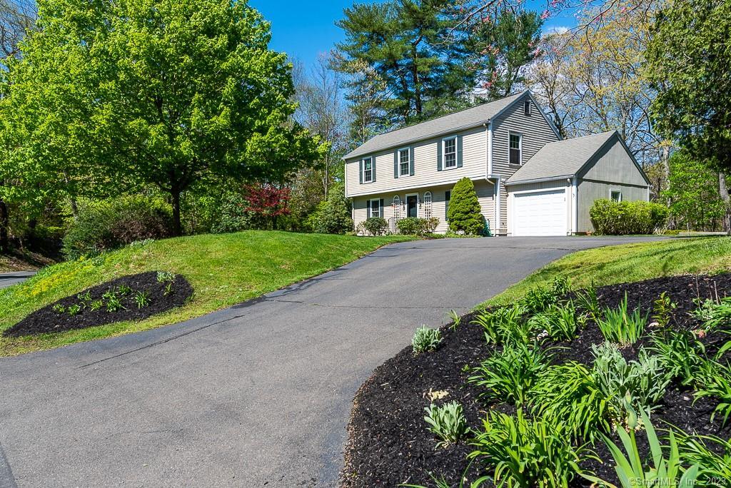 a front view of a house with a yard and shrubs