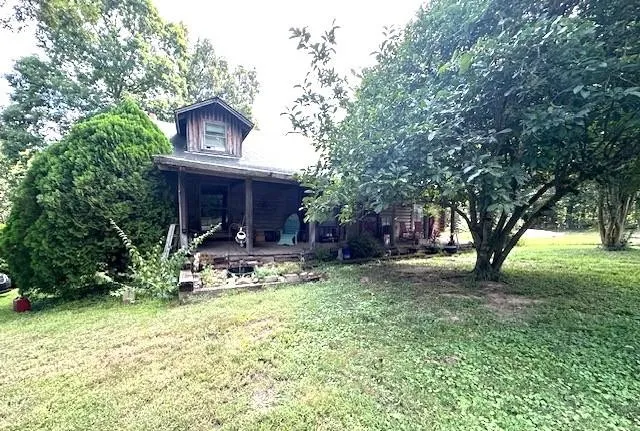 a view of house with yard and sitting area
