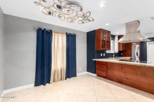 a large kitchen with a chandelier stainless steel appliances a counter space and cabinets