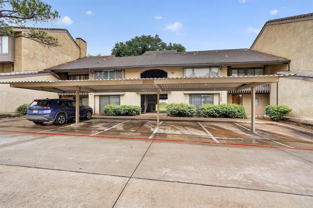 a front view of a building with cars parked