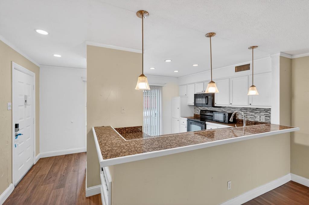 4549 North O'Connor Road, Unit 1262 Irving, TX 75062 - Photo 6 of 21 a kitchen with stainless steel appliances granite countertop a sink a refrigerator and a wooden floor